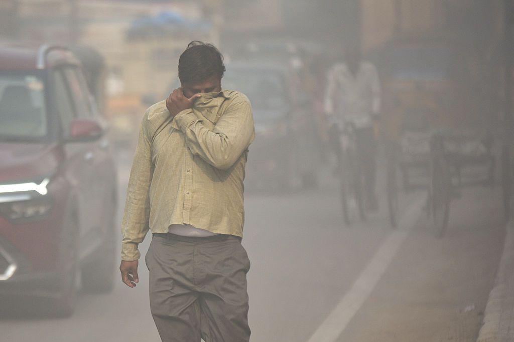 Image caption,A pedestrian walks through a haze of dust pollution in Hyderabad