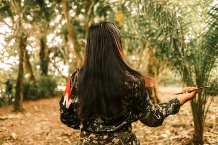 An ELN member adjusts another’s beret before military exercises in southern Chocó.Photograph: Santiago Mesa/The Guardian