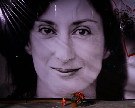Flowers placed in front of a portrait of murdered journalist Daphne Caruana Galizia during a vigil outside the law courts in Valletta, Malta.Photograph: Jonathan Borg/AP