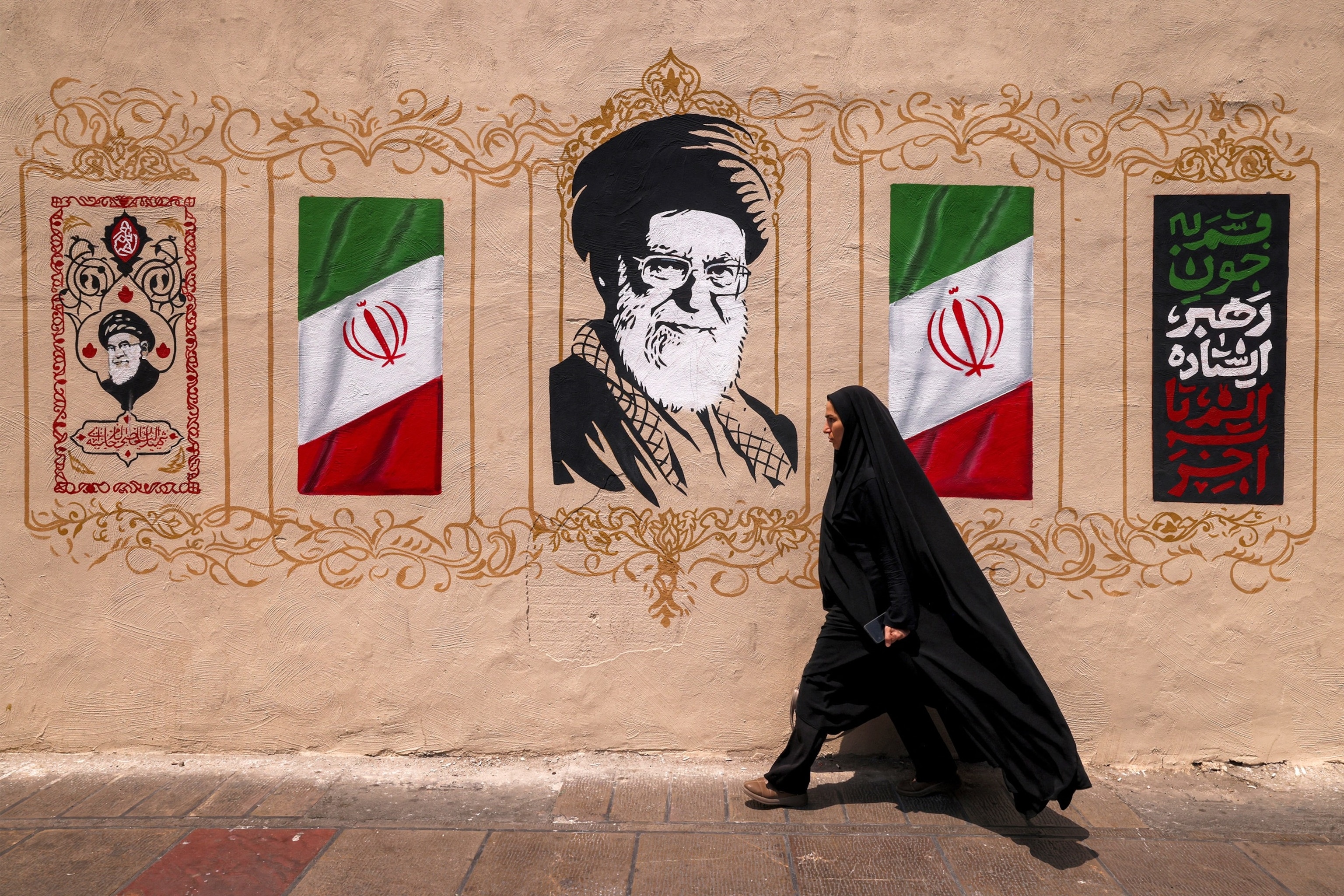 A woman walks past a mural depicting Iran's late supreme leader Ali Khamenei at Valiasr Square in central Tehran on Aug. 8, 2026.Atta Kenare/AFP via Getty Images