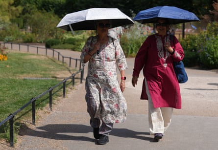 People using umbrellas as parasols in Hyde Park, London.Photograph: Maja Smiejkowska/PA