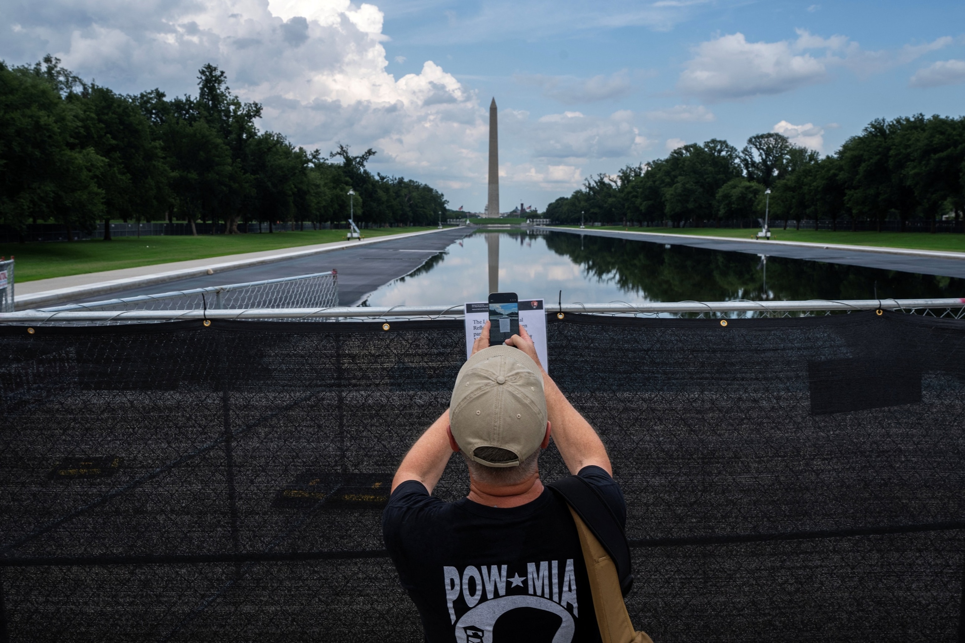 A visitor photographs a sign describing ongoing work attached to fencing surrounding the Lincoln Memorial Reflecting Pool in Washington, D.C., on Aug. 8, 2026.Nathan Howard/Reuters