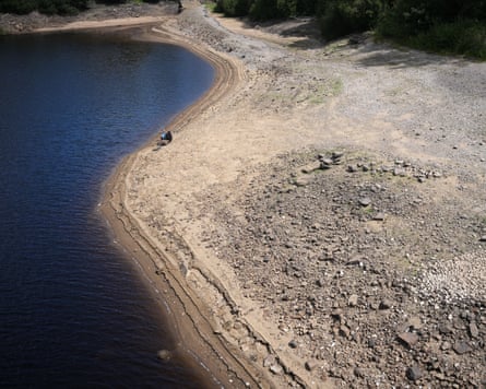 A man fishes from the dried-out bed of Ladybower reservoir in the Derwent valley.Photograph: Christopher Furlong/Getty Images
