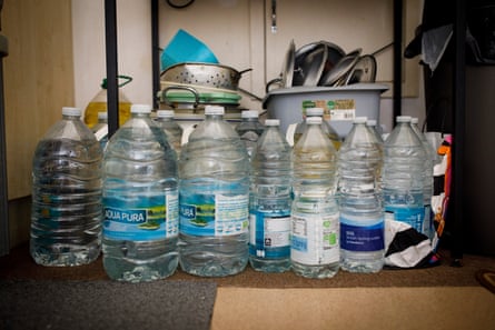 Bottles of water in one resident’s flat, ready for the next outage.Photograph: Alicia Canter/The Guardian