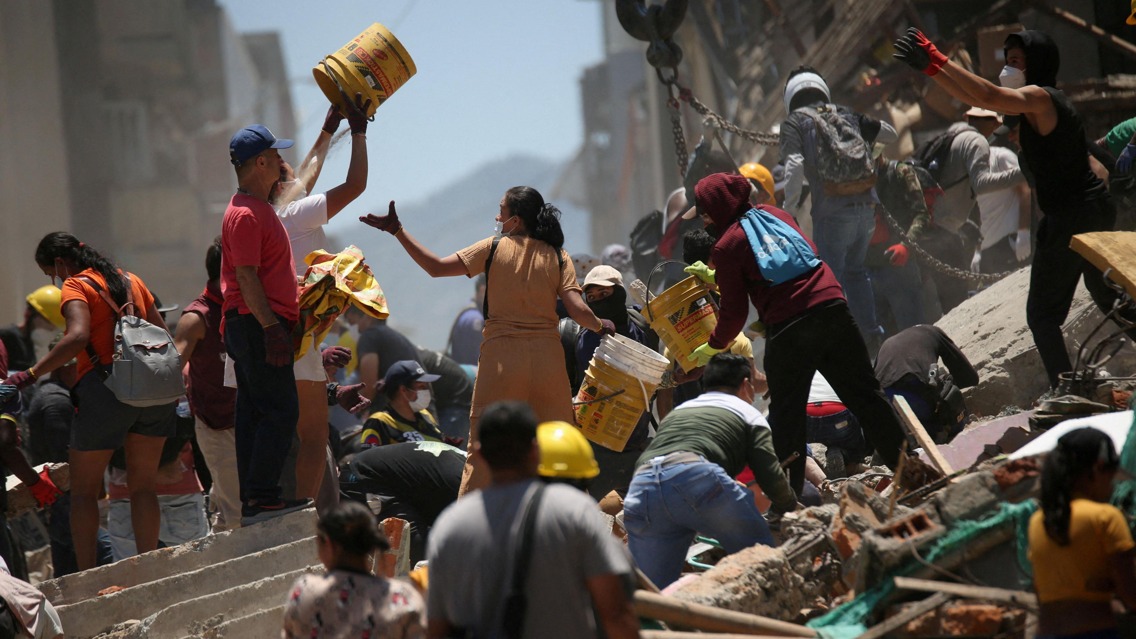 Image caption,Large numbers of volunteers joined the effort to free survivors in Pereira
