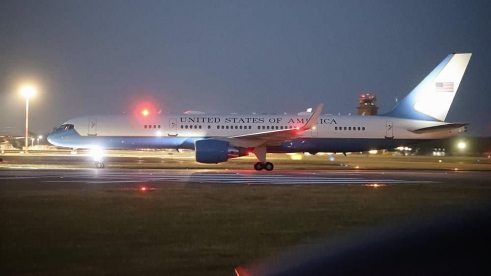 Image caption,The C-32A with Trump on board lands RAF Mildenhall