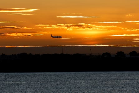 A plane prepares to land at Sydney airport, the busiest airport in Australia.Photograph: Izhar Khan/Reuters