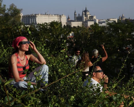 People use protective glasses to observe a partial solar eclipse from the Debod Temple, near the Royal Palace in Madrid, Spain.Photograph: Alejandro Martinez Velez/Reuters