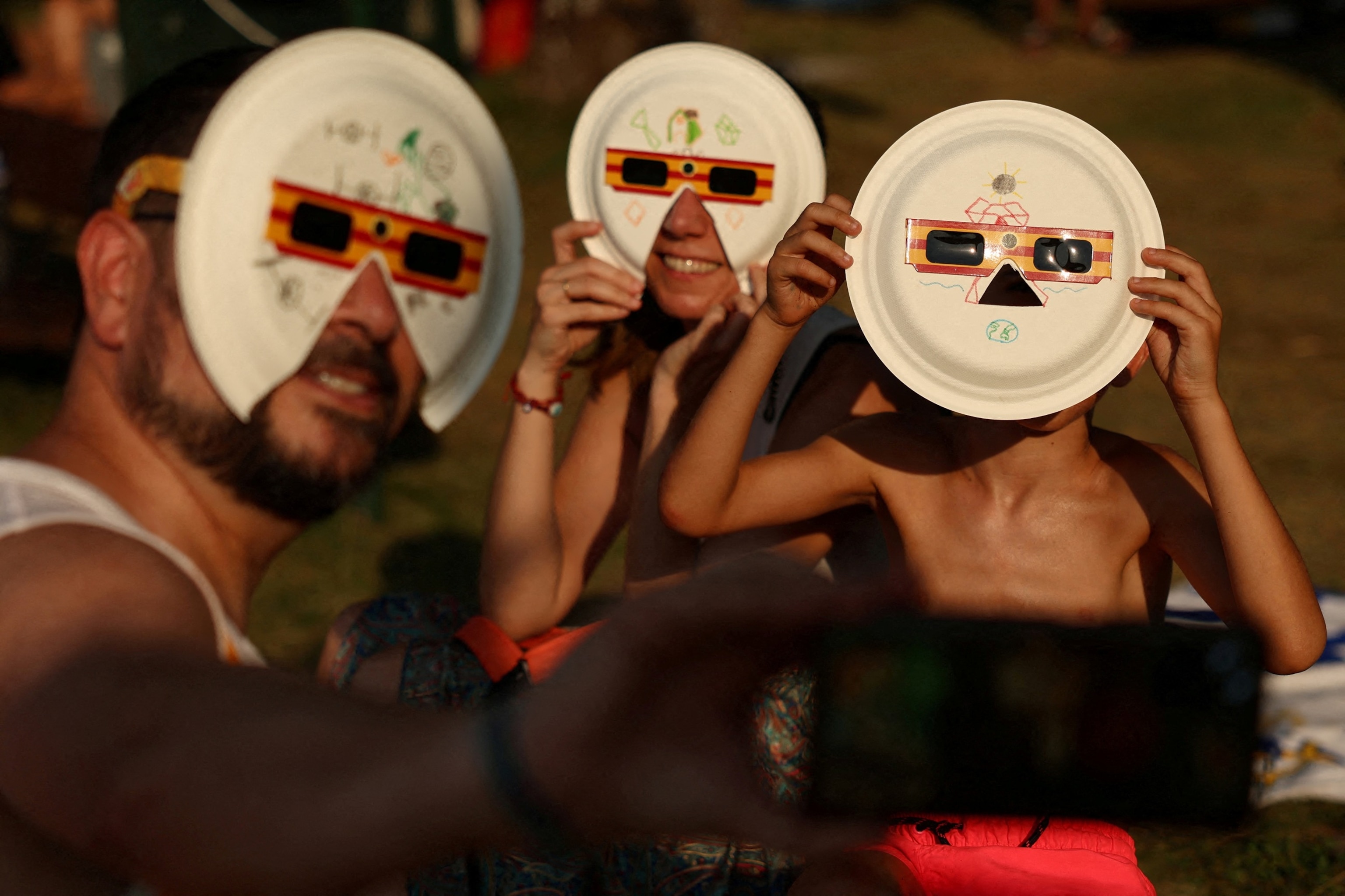Angela, David and their son, Diego, 7, pose for a selfie with protective eclipse glasses during the watch party for the solar eclipse, in Buitrago del Lozoya, Spain, August 12, 2026.Susana Vera/Reuters