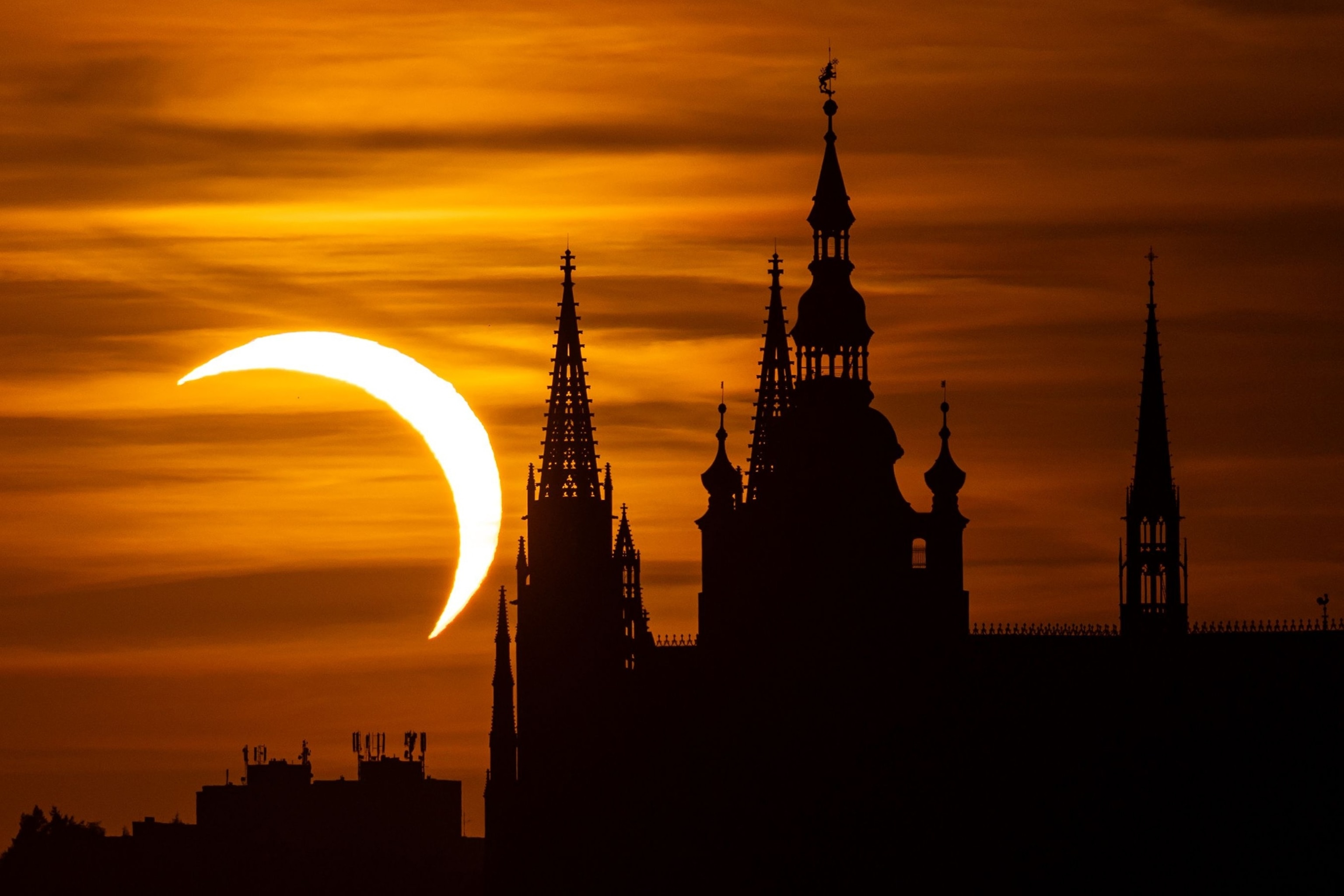 In this image of the sun during a partial solar eclipse and partially obscured by clouds, the International Space Station is seen in silhouette as it transits at roughly five miles per second, Aug. 12, 2026, near Hodgdon, Maine.Joel Kowsky/NASA