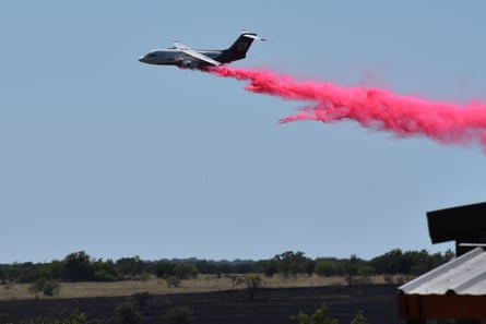 A tanker aircraft dumps fire retardant on a field south-west of Salado, Texas, after a military helicopter crashed and sparked a grass fire, on 12 August.Photograph: Brent Johnson/The Killeen Daily Herald/AP