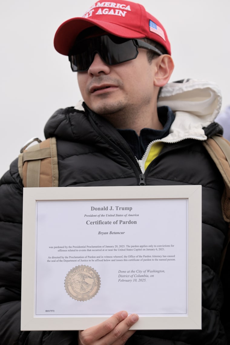 Bryan Betancur displays his certificate of pardon from President Donald Trump at a Jan. 6 memorial march in Washington this year.Chip Somodevilla / Getty Images file
