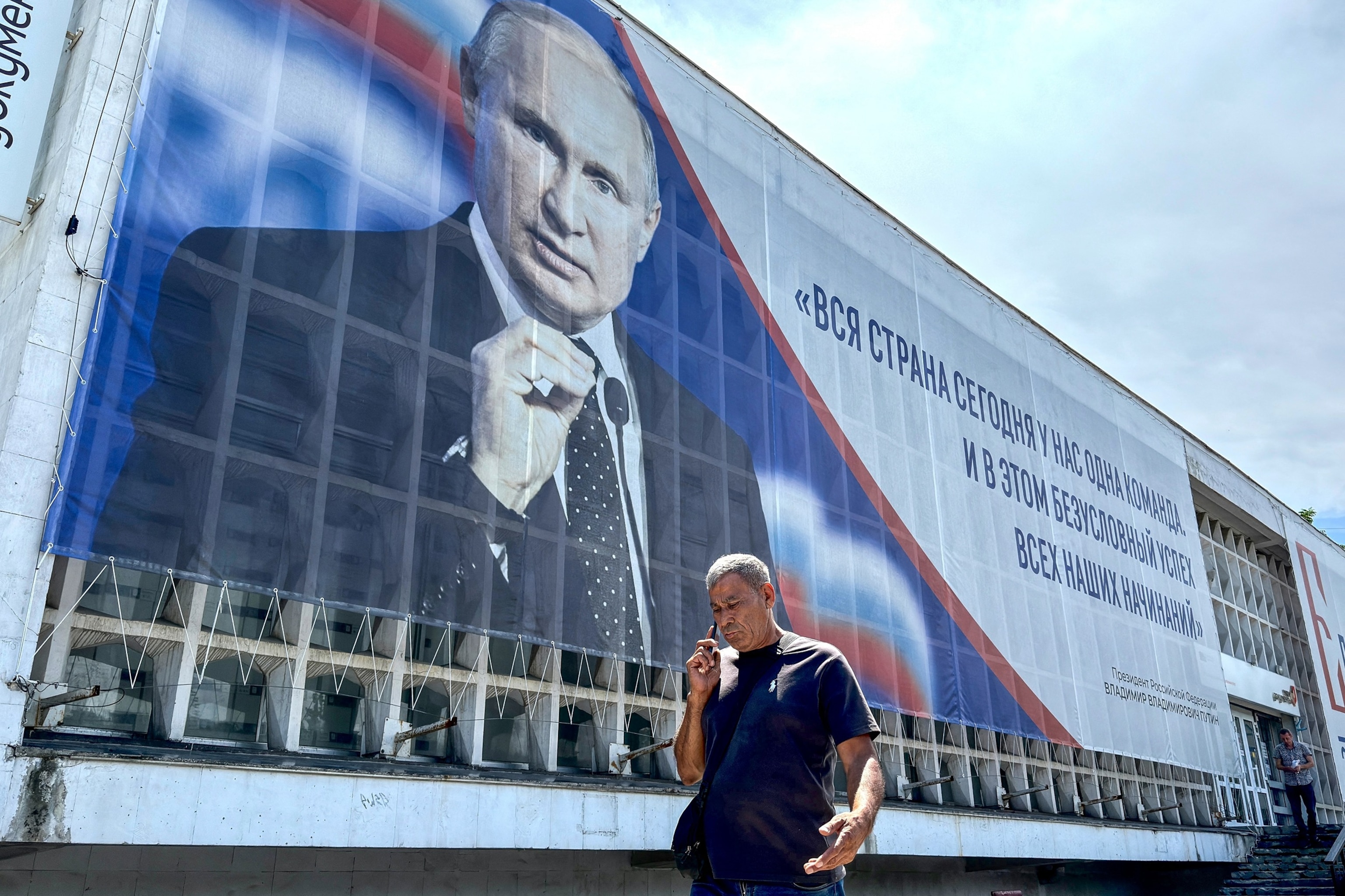 This file photo shows a man walking past a billboard displaying a portrait of Russian President Vladimir Putin in Sevastopol, Crimea, on July 23, 2026.Images)Igor Ivanko/AFP via Getty Images