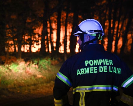 A firefighter with the French air force looks on as a wildfire burns through the Landes forest in Luglon, south-west France.Photograph: Romain Perrocheau/AFP/Getty Images