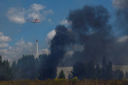 A firefighting helicopter drops water over a food warehouse damaged during Russian drone strikes near Kyiv, 12 August 2026.Photograph: Valentyn Ogirenko/Reuters