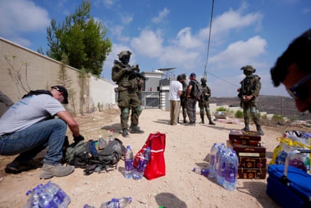 Palestinian, Israeli and foreign activists attempt to deliver basic supplies to three Palestinian families under siege by settlers in Qusra.Photograph: Anadolu/Getty Images