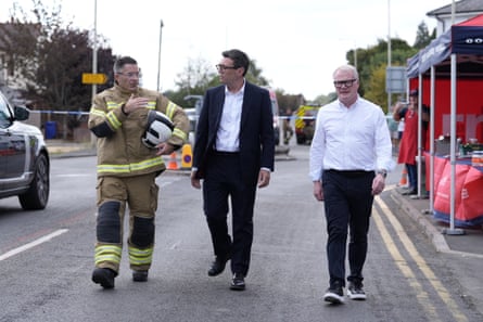 Andy Burnham and the West Midlands mayor, Richard Parker, right, with the West Midlands chief fire officer, Simon Tuhill, during a visit to Stourbridge on Friday.Photograph: Peter Byrne/Reuters