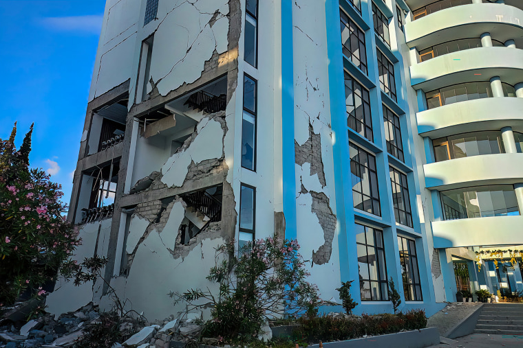 Photo released by the Indonesian National Search and Rescue Agency (BASARNAS), rescuers attempt to clear debris at building damaged by earthquake in Maumere, East Nusa Tenggara Province, Indonesia, on Saturday.BASARNAS via AP