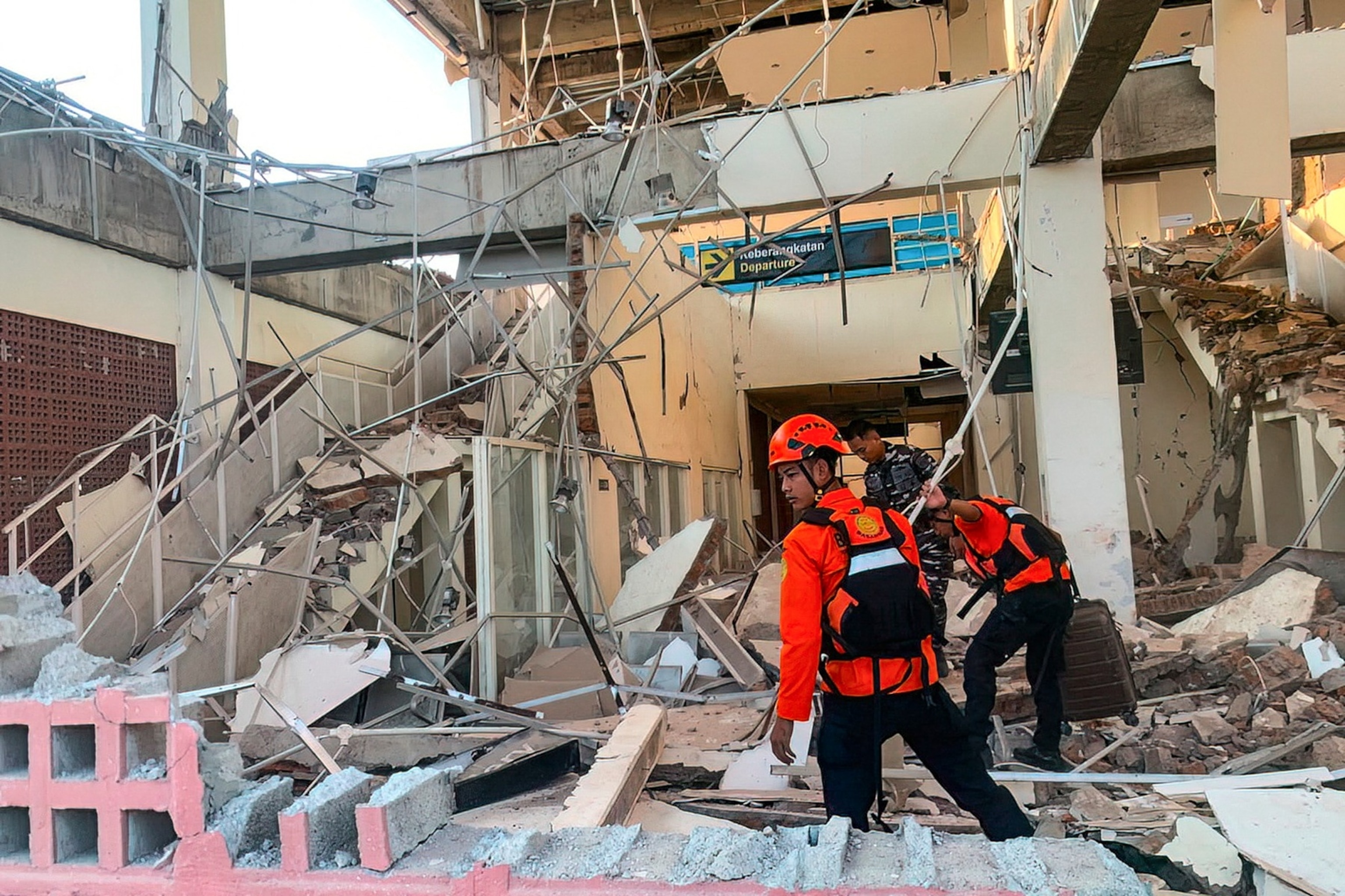 This handout picture taken and released on August 15, 2026 by Indonesia's National Search and Rescue Agency (BASARNAS) shows rescuers working amid the rubble of a damaged building after an earthquake in Maumere, East Nusa Tenggara. A powerful 7.7-magnitude earthquake struck off Flores island in eastern Indonesia early on August 15, killing at least two and sending thousands running in panic after authorities issued a tsunami warning.Handout / INDONESIA'S NATIONAL SEARCH AND RESCUE AGENCY (BASARNAS) / AFP via Getty Images) /