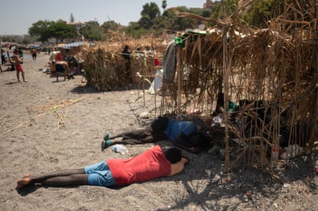 Migrants seen sheltering from the sun on El Trampolin beach in Ceuta.Photograph: Jorge Guerrero/AFP/Getty Images