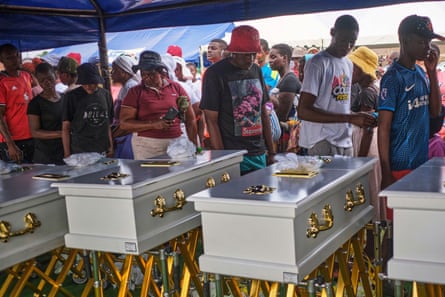 Family members walk past caskets carrying their loved ones during a memorial service for the victims of the boat accident in Kariba, Zimbabwe, 13 August 2026.Photograph: Mkhululi Thobela/AP