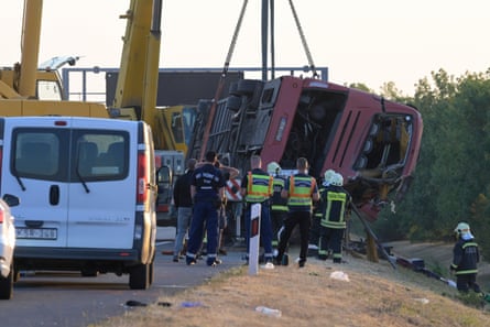 A crane lifts the bus from the side of the motorway.Photograph: Zoltán Máthé/EPA
