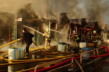 Firefighters work to put out a fire at a book market in Kyiv on Sunday.Photograph: Dan Bashakov/AP