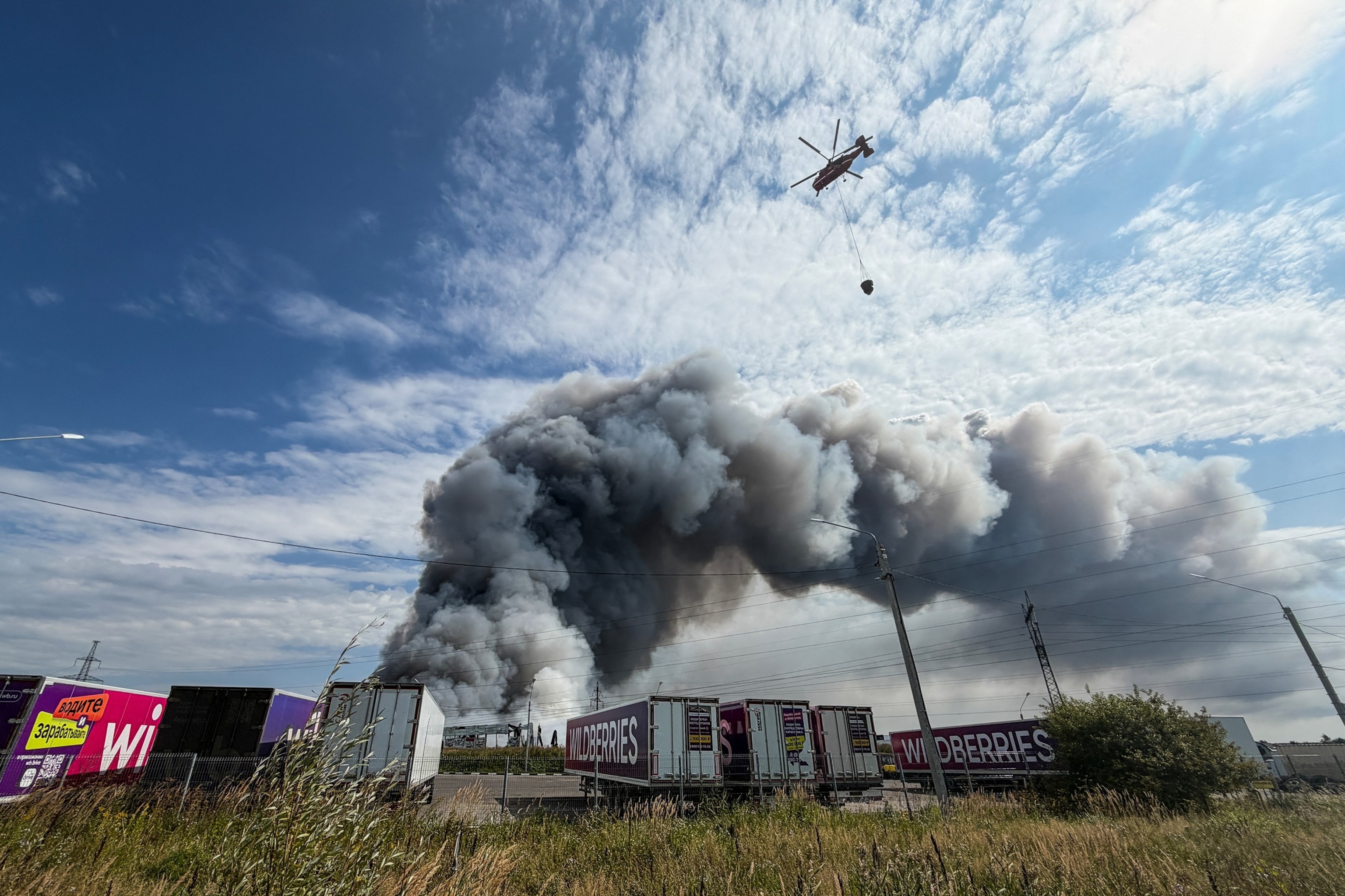 A firefighting helicopter prepares to drop a load of water during a fire at Russian e-commerce firm Wildberries' logistics complex near the town of Podolsk, outside Moscow, on Aug. 16, 2026.Tatyana Makeyeva/AFP via Getty Images