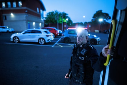 Neighbourhood chief inspector James Grundy waits in the Hyde police station car park before carrying out dawn raids.Photograph: Joel Goodman/The Guardian