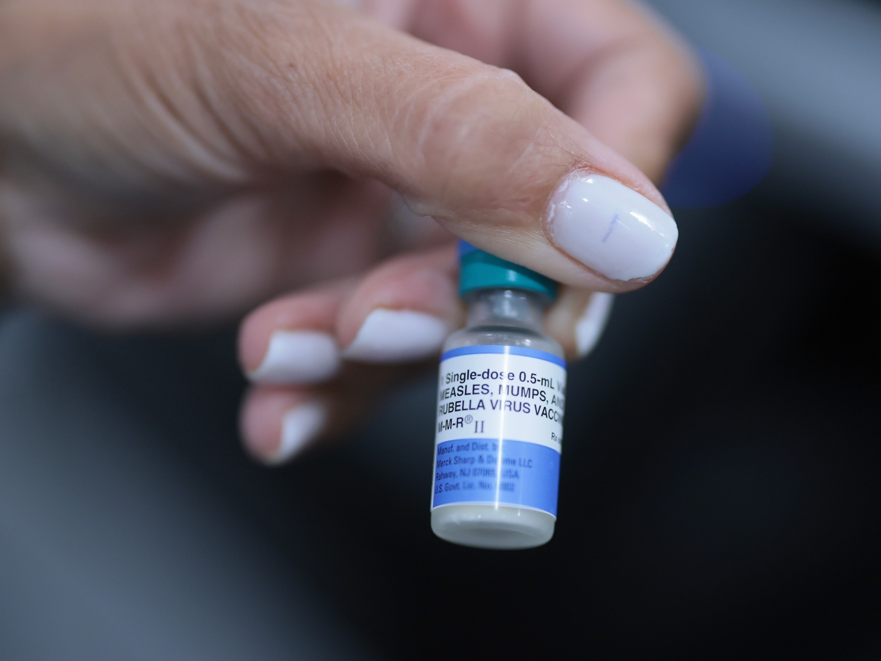 A medical assistant holds a measles, mumps and rubella vaccine at the pediatric office of Dr. Gary M. Kramer in Coral Gables, Fla., on Aug. 13, 2026. President Donald Trump signed an executive order on Monday to overhaul childhood vaccination policy.Joe Raedle/Getty Images