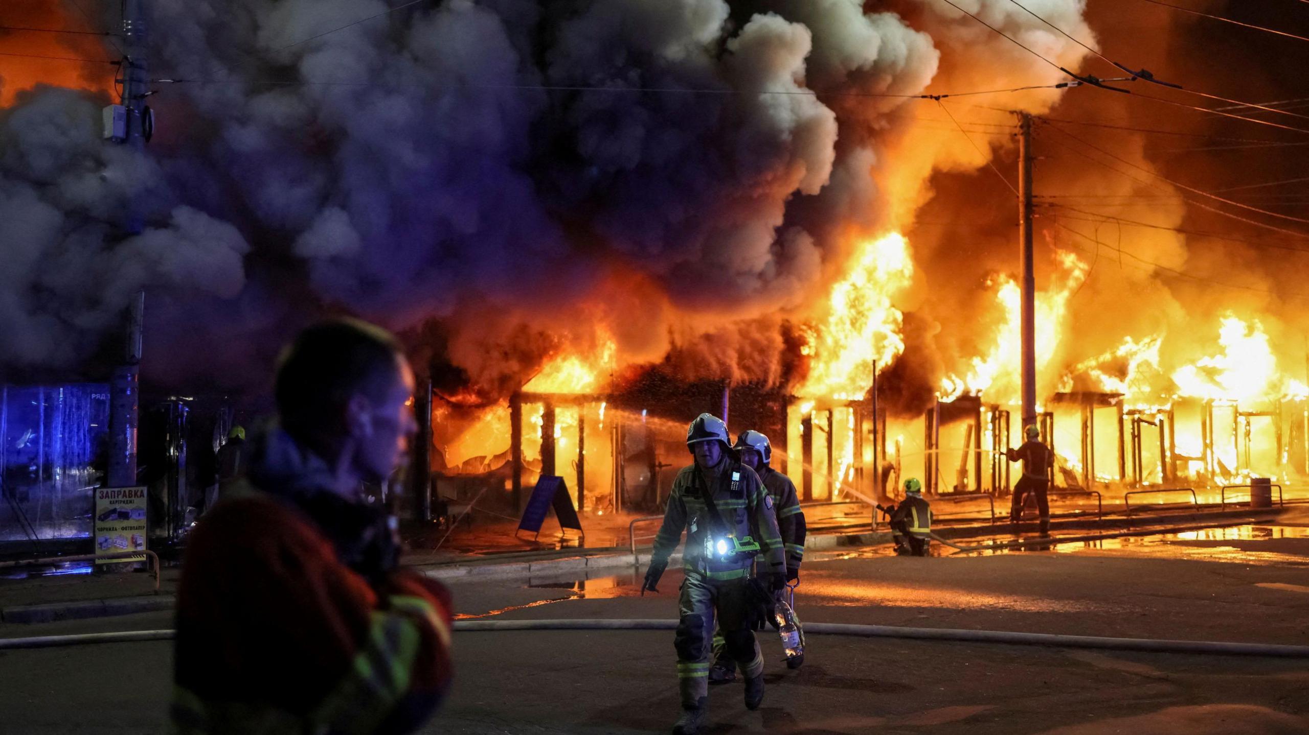 Image caption,Ukrainian firefighters tackle a blaze after a Russian strike that destroyed a famous book market in Kyiv. Photo: 16 August 2026