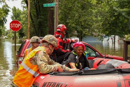 First responders helping a resident in flood waters in Indianapolis, Indiana, on 15 August.Photograph: Indianapolis Fire Department/AFP/Getty Images