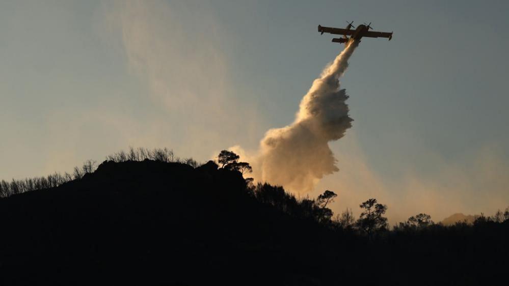 Image caption,Planes were seen carrying out operations to extinguish fires on Greece's Salamina Island on Sunday