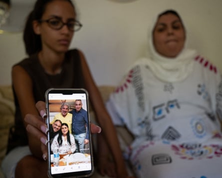 Fakir’s sister Khadija (right) with his niece Yossra, showing a photo of him with family members.Photograph: Michele Lapini/Reuters