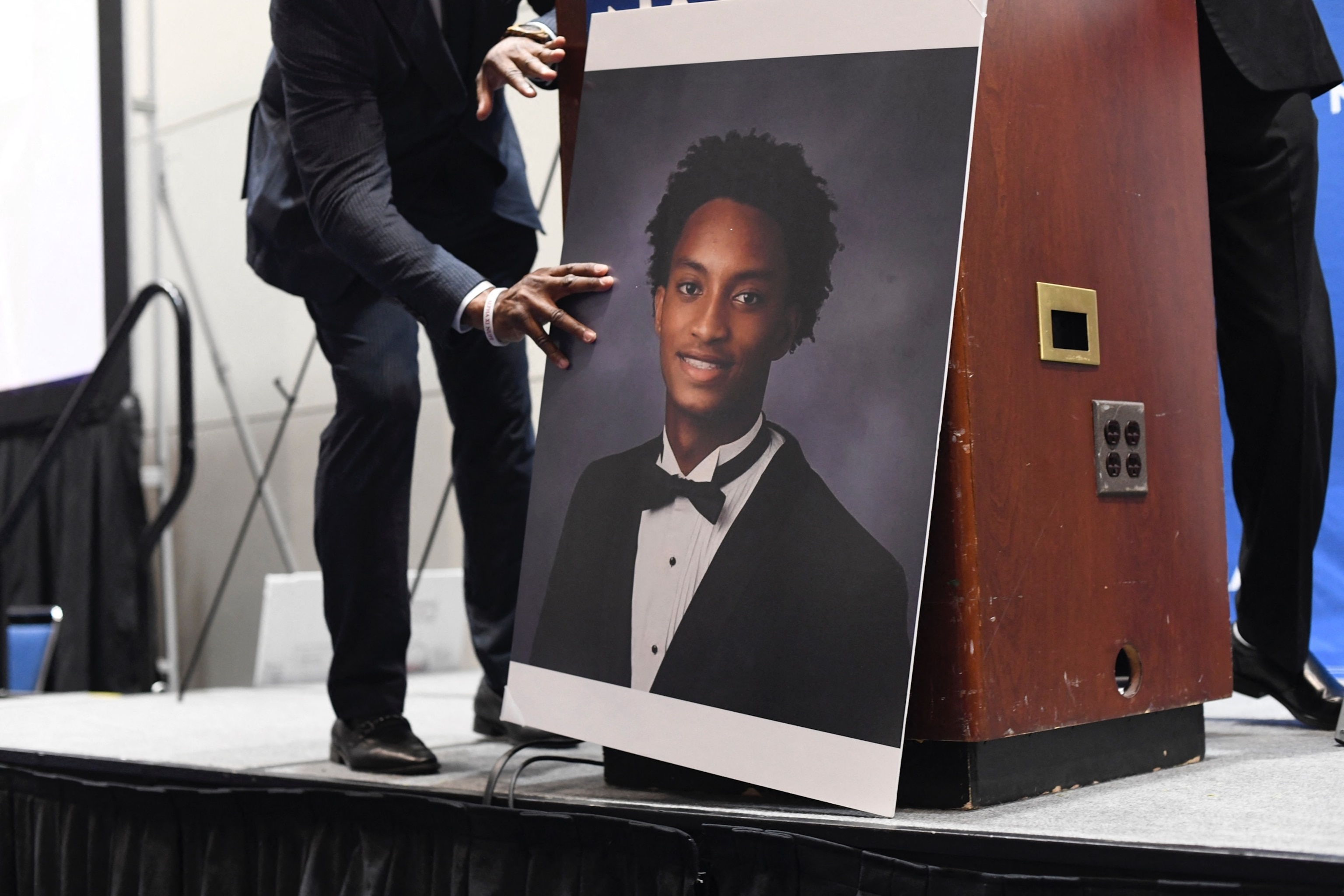 A man places a photograph of Nolan Xavier Wells in front of the podium before a news conference during the 117th NAACP National Convention at McCormick Place in Chicago, Illinois, on July 22, 2026.Octavio Jones/AFP via Getty Images