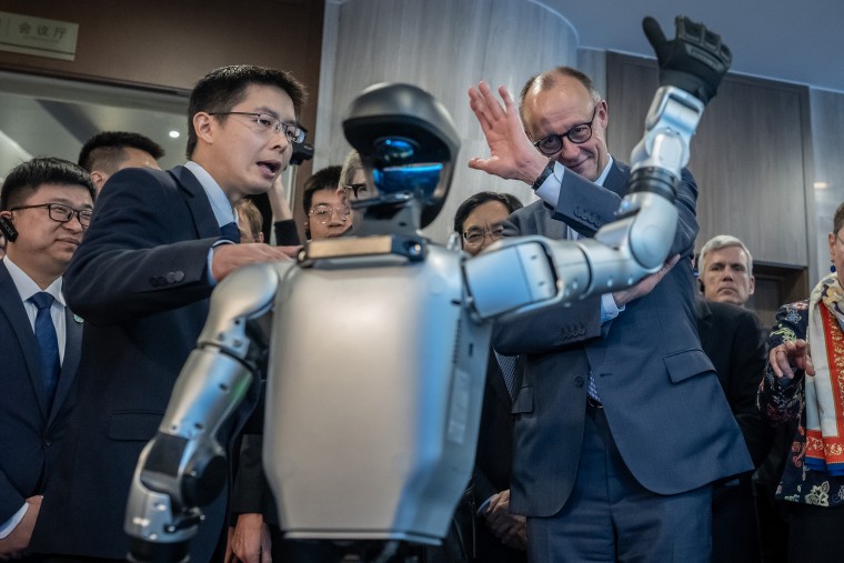 Unitree CEO Wang Xingxing, left, and German Chancellor Friedrich Merz, right, at a Unitree Robotics showroom in Zhejiang in Feb.Michael Kappeler / dpa/picture alliance via Getty Images