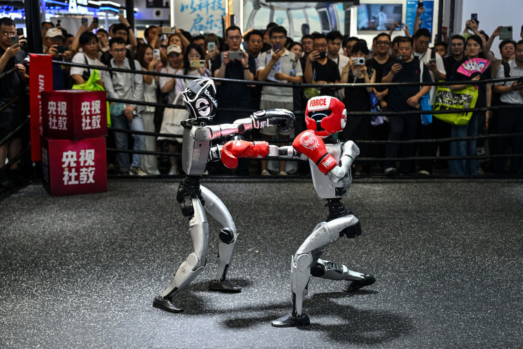 Humanoid robots controlled by a remote control take part in a fight during the World Artificial Intelligence Conference in July.Hector Retamal / AFP via Getty Images