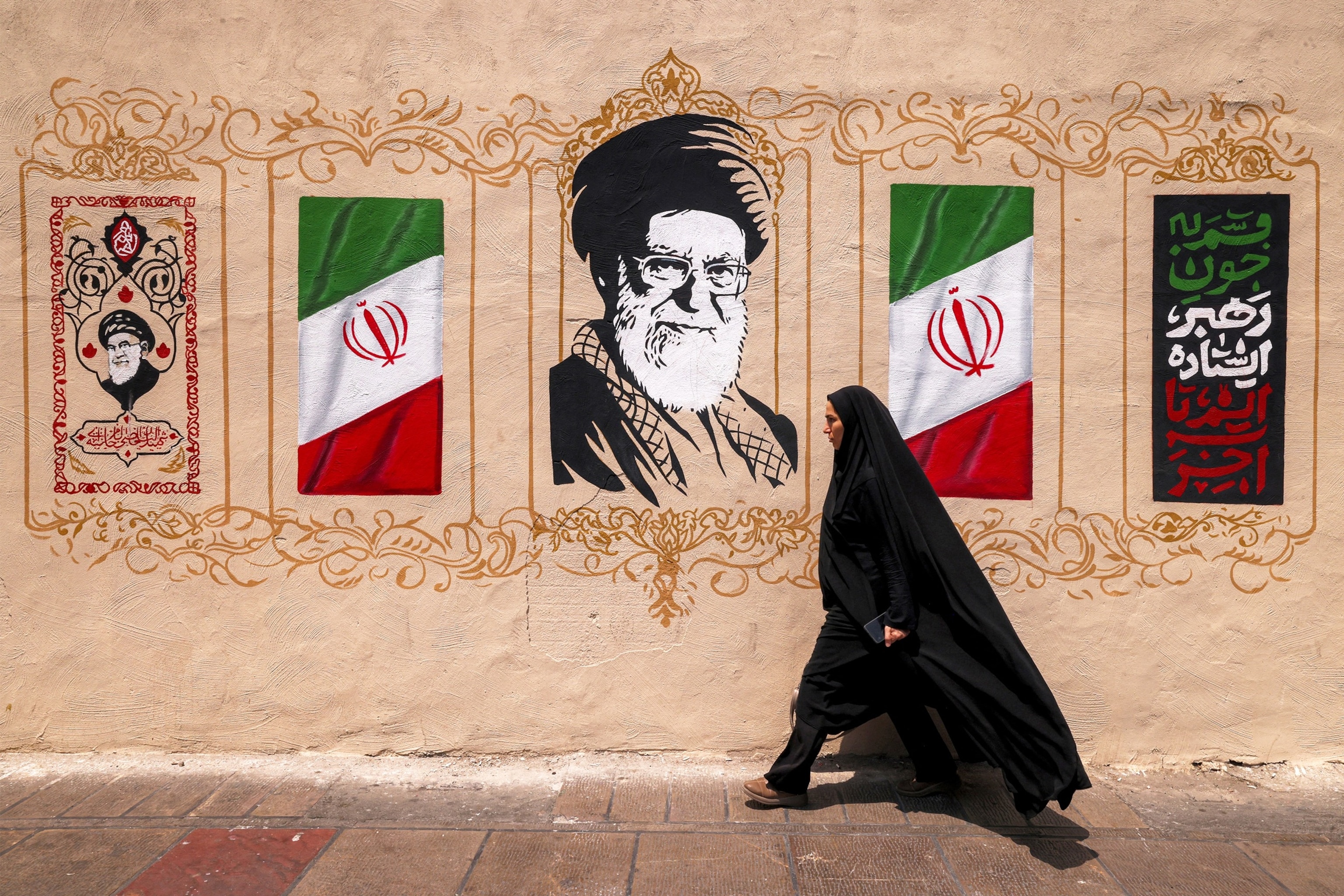 A woman walks past a mural depicting Iran's late supreme leader Ali Khamenei at Valiasr Square in central Tehran on Aug. 8, 2026.Atta Kenare/AFP via Getty Images