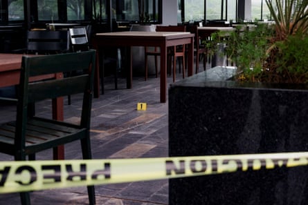 An evidence marker is placed next to blood stains at a hotel restaurant where Nadia Beller was shot by a man dressed as a delivery rider.Photograph: Ipa Ibanez/Reuters