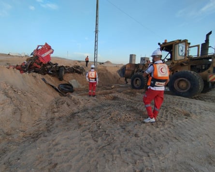 Red Crescent paramedics at the mass grave where their colleagues’ bodies were buried.Photograph: OCHA/Red Crescent
