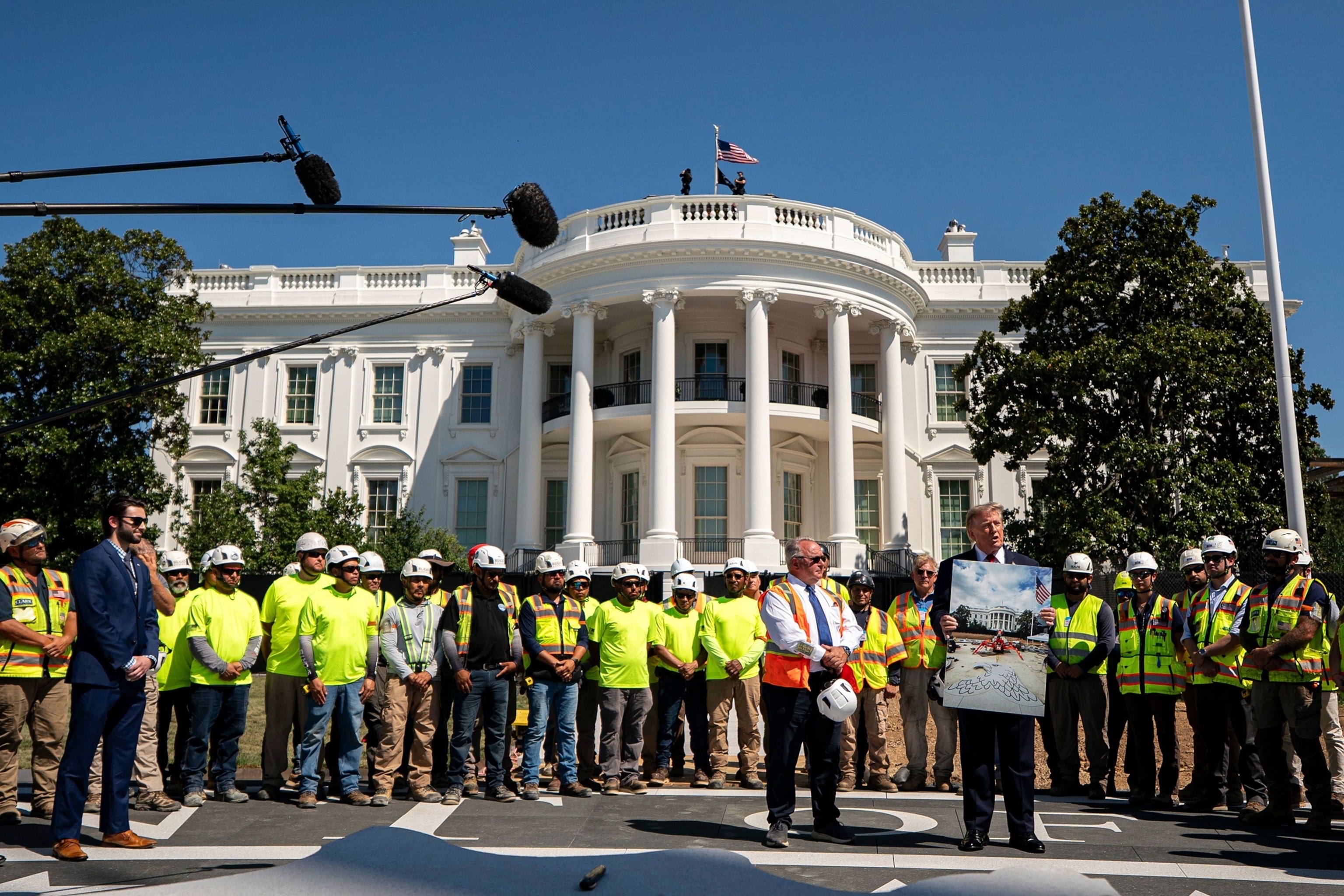 President Donald Trump stands with workers near the White House helipad construction on the South Lawn of the White House in Washington, August 19, 2026.Al Drago/EPA/Shutterstock