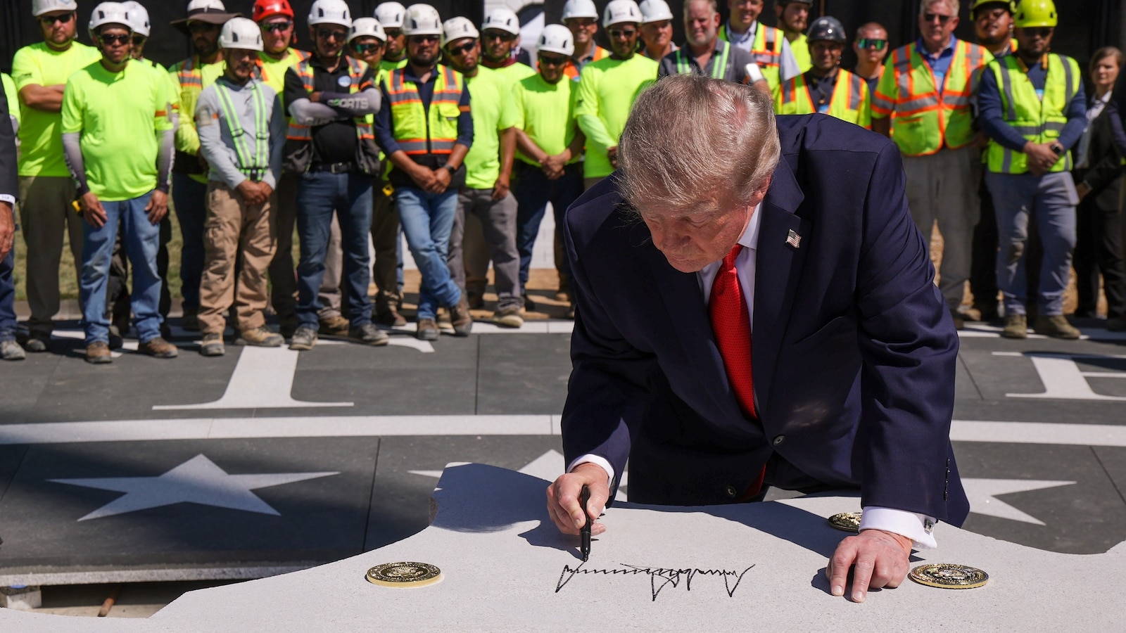 President Donald Trump signs a piece of stone at the construction site of a helipad on the South Lawn of the White House in Washington, August 19, 2026.Alex Wong/Getty Images