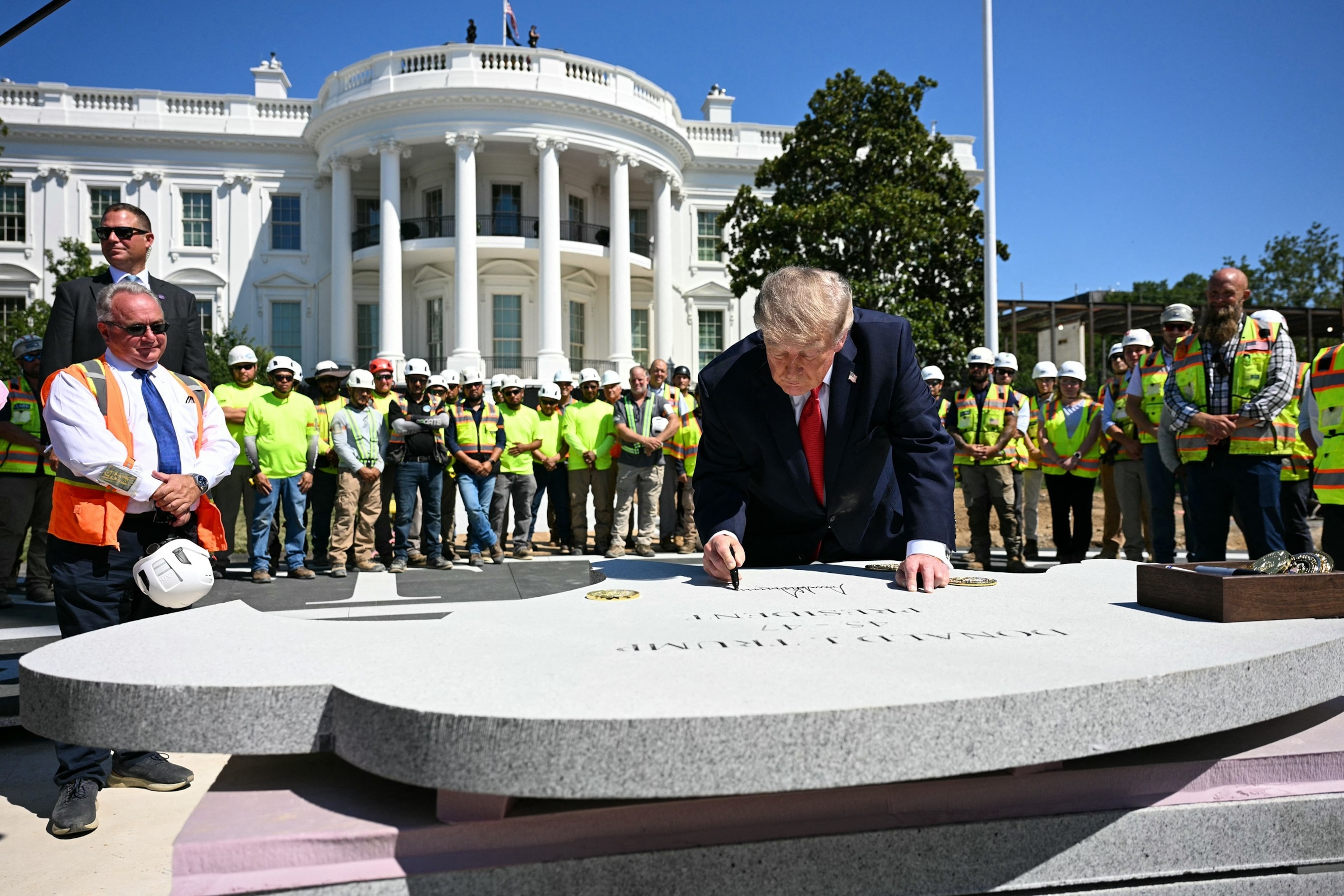 President Donald Trump signs a piece of stone at the construction site of a helipad on the South Lawn of the White House in Washington, August 19, 2026.Jim Watson/AFP via Getty Images