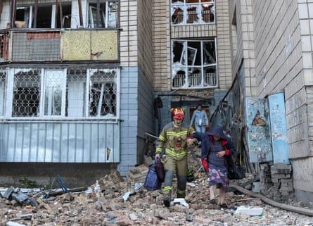 A rescuer evacuates a woman from an apartment building in Kyiv on Thursday.Photograph: Anatolii Stepanov/Reuters