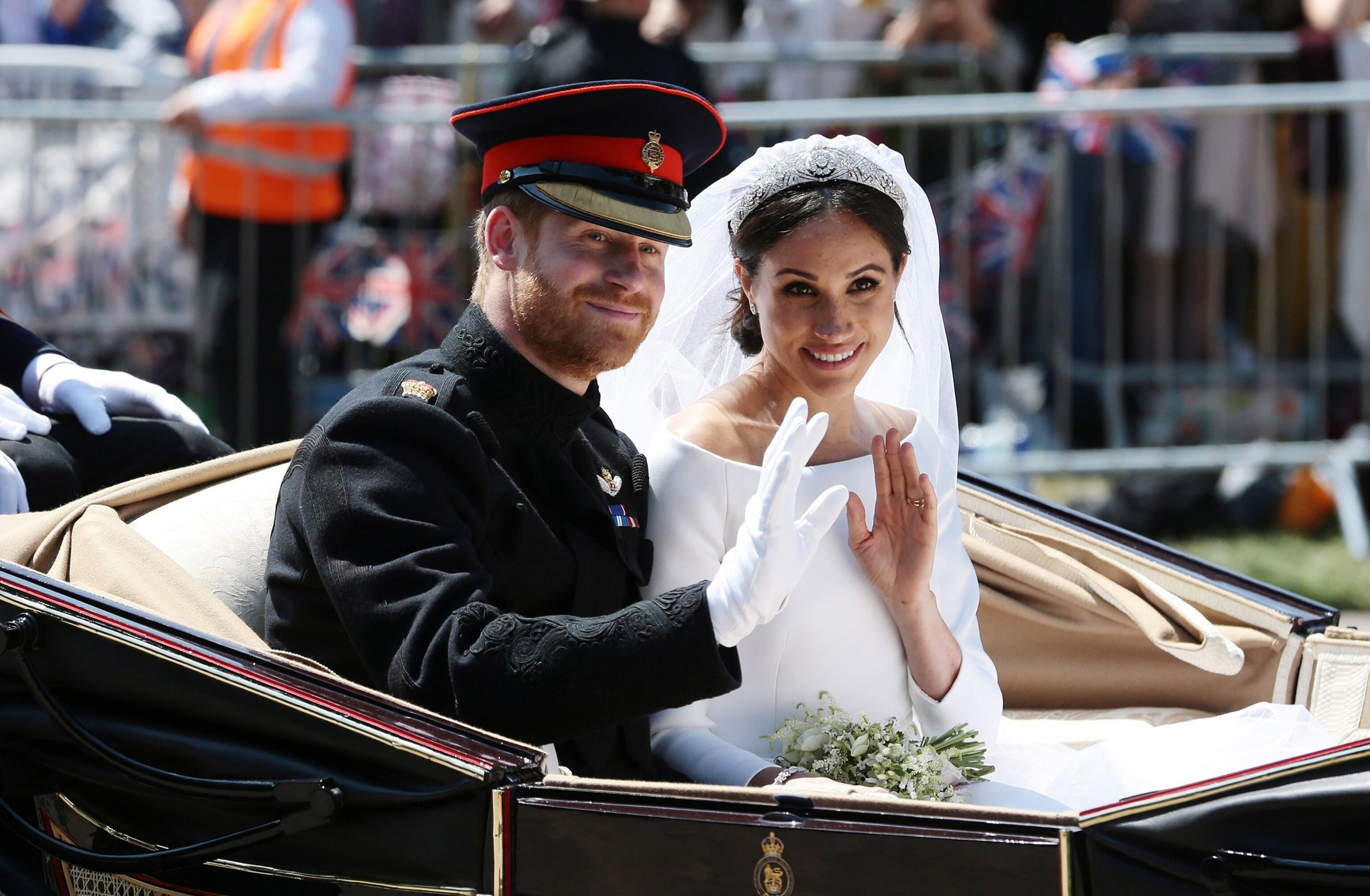 Prince Harry, Duke of Sussex and Meghan, Duchess of Sussex wave during their carriage procession on Castle Hill outside Windsor Castle in Windsor, on May 19, 2018 after their wedding ceremony.Aaron Chown/WPA Pool/Getty Images