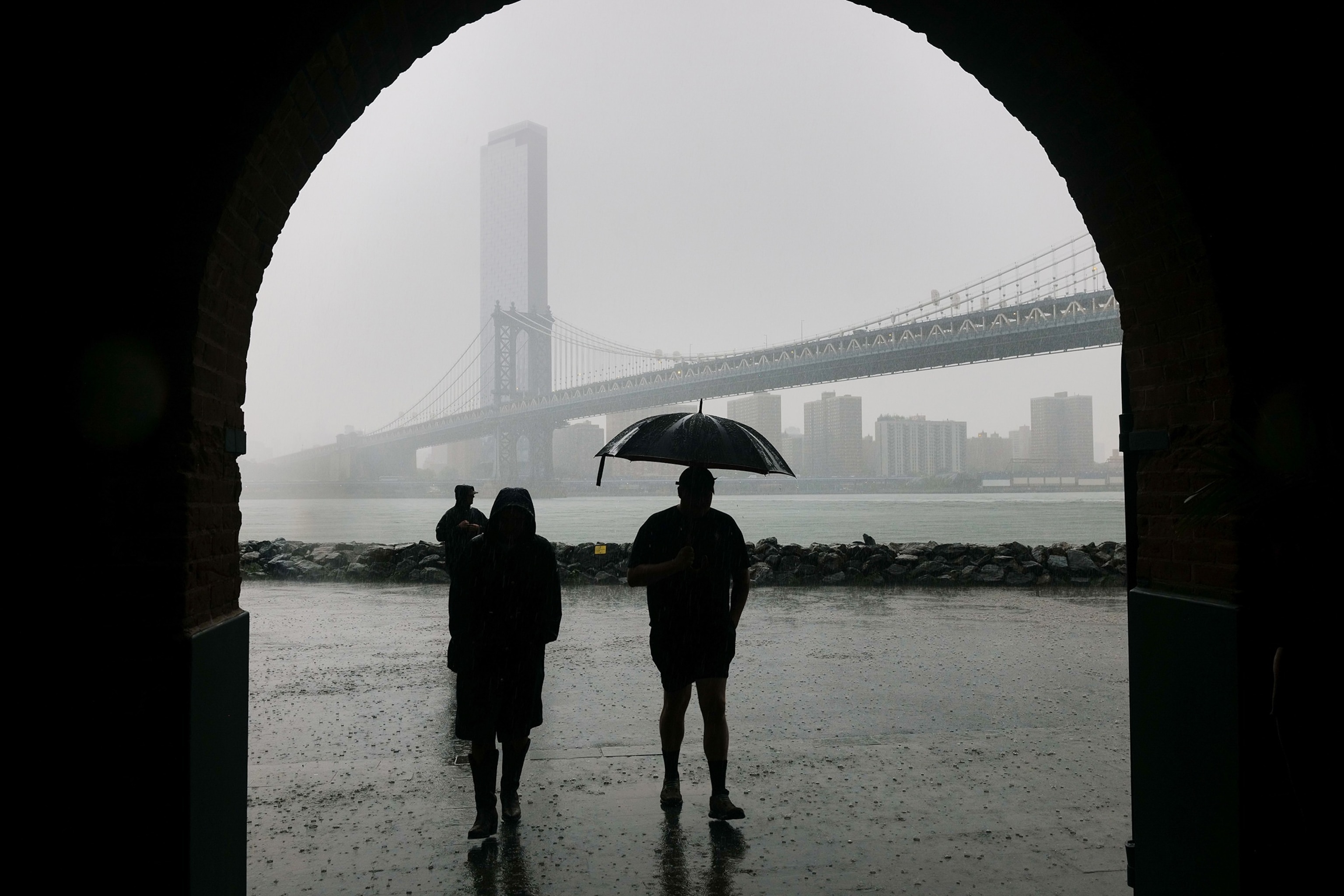 People walk through the rain in the Dumbo neighborhood in Brooklyn as severe storms move through the New York area on July 21, 2026 in New York City.Spencer Platt/Getty Images