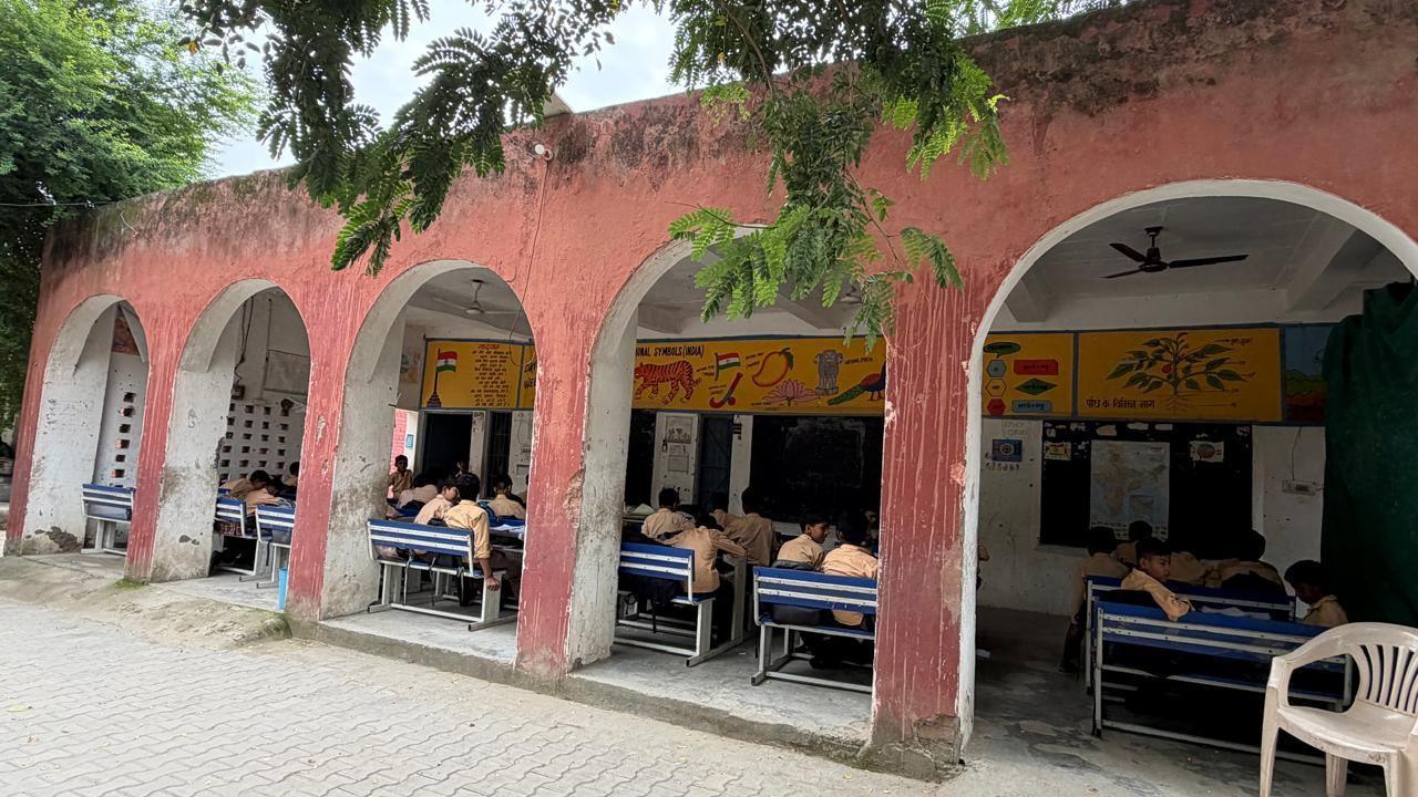 Image caption,A shortage of classrooms after one of the school buildings was demolished for being too unsafe has meant classes are being held in the school veranda