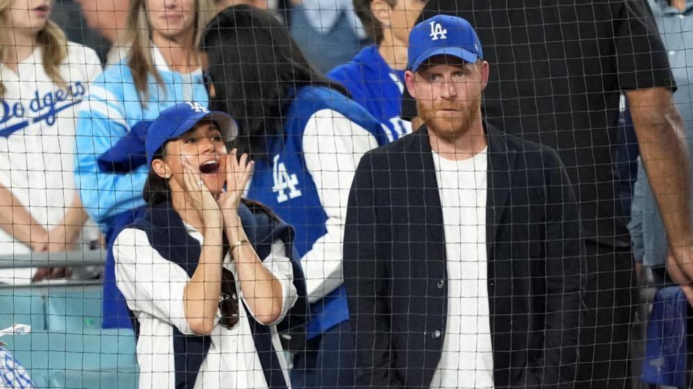 Image caption,Harry and Meghan attending a Los Angeles Dodgers game in October 2025