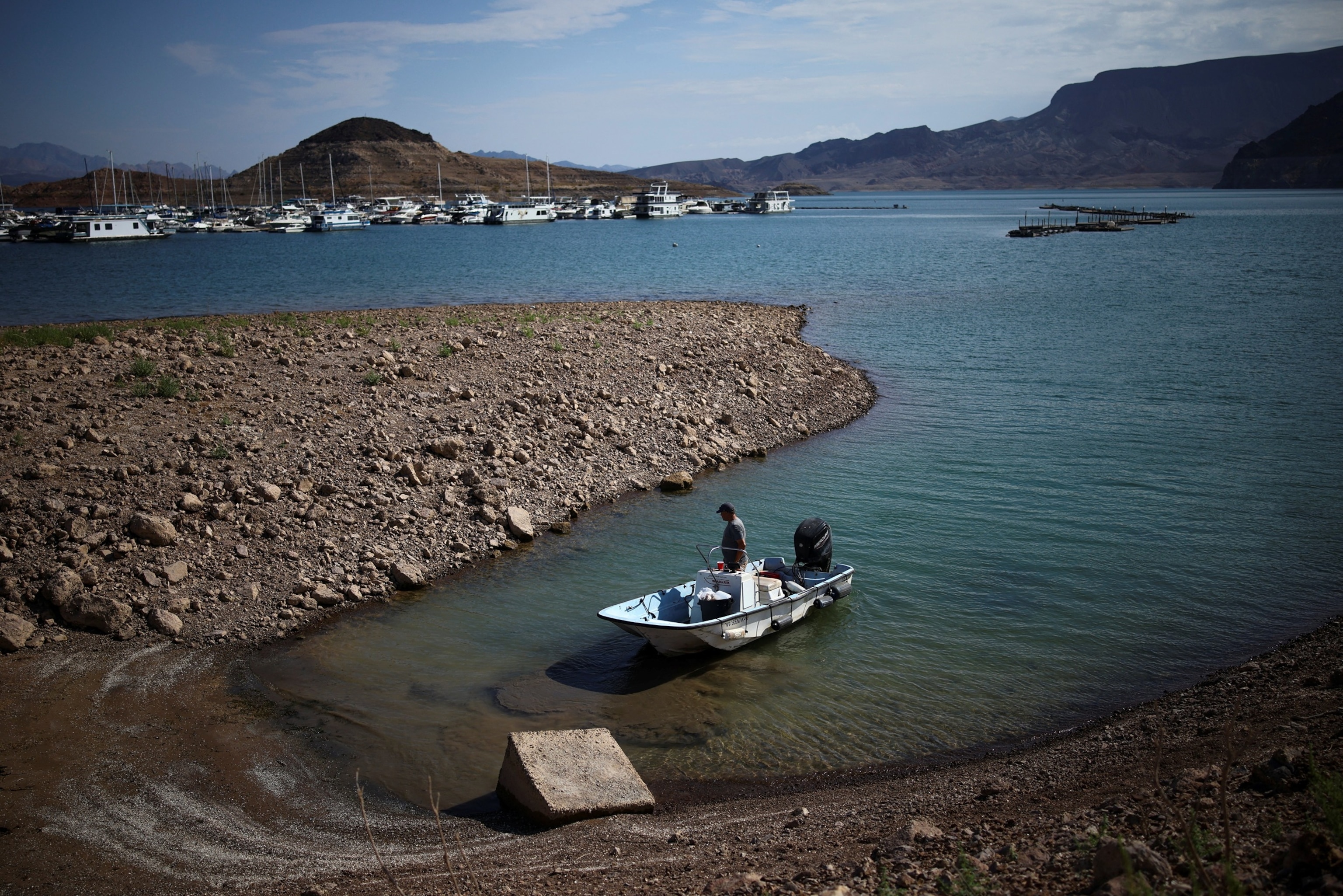 A man wades his boat into the receding shoreline of Lake Mead, the largest reservoir in the United States by water capacity, highlighting the long-term effects of drought and water demand on the Colorado River system, near Boulder City, Nevada, U.S., August 12, 2026.Daniel Cole/Reuters