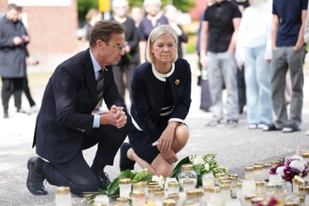 The Swedish prime minister, Ulf Kristersson, (L) and the Social Democratic party leader, Magdalena Andersson, visit the makeshift memorial.Photograph: Magnus Lejhall/EPA